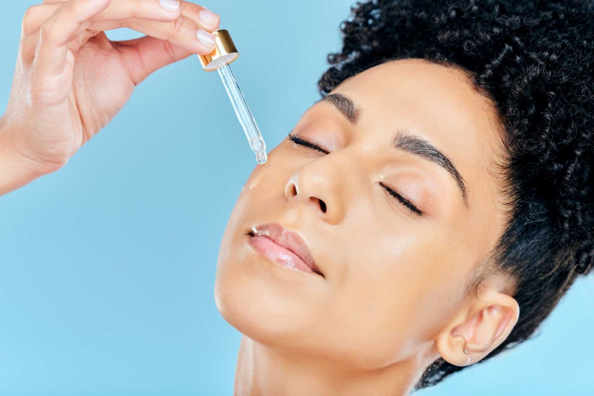 Woman applying facial serum with dropper