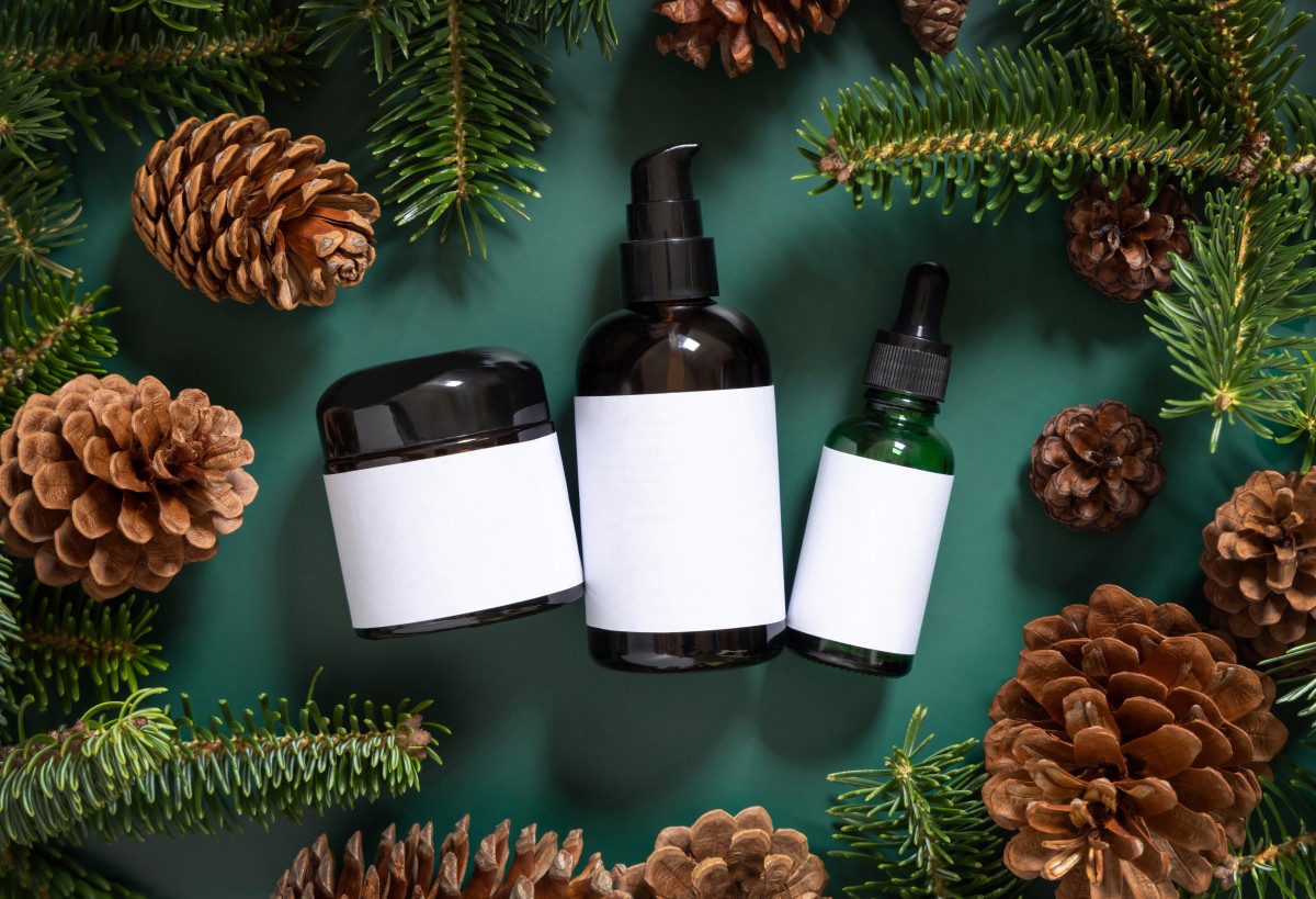 Cosmetic bottles with pine cones and spruce branches