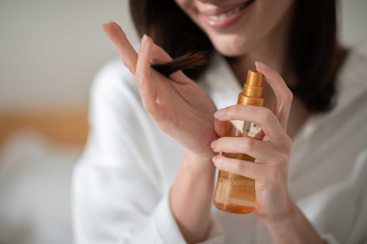 Woman applying hair serum for healthy hair care