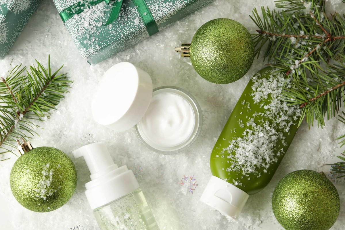 Holiday skincare products with green ornaments and snow