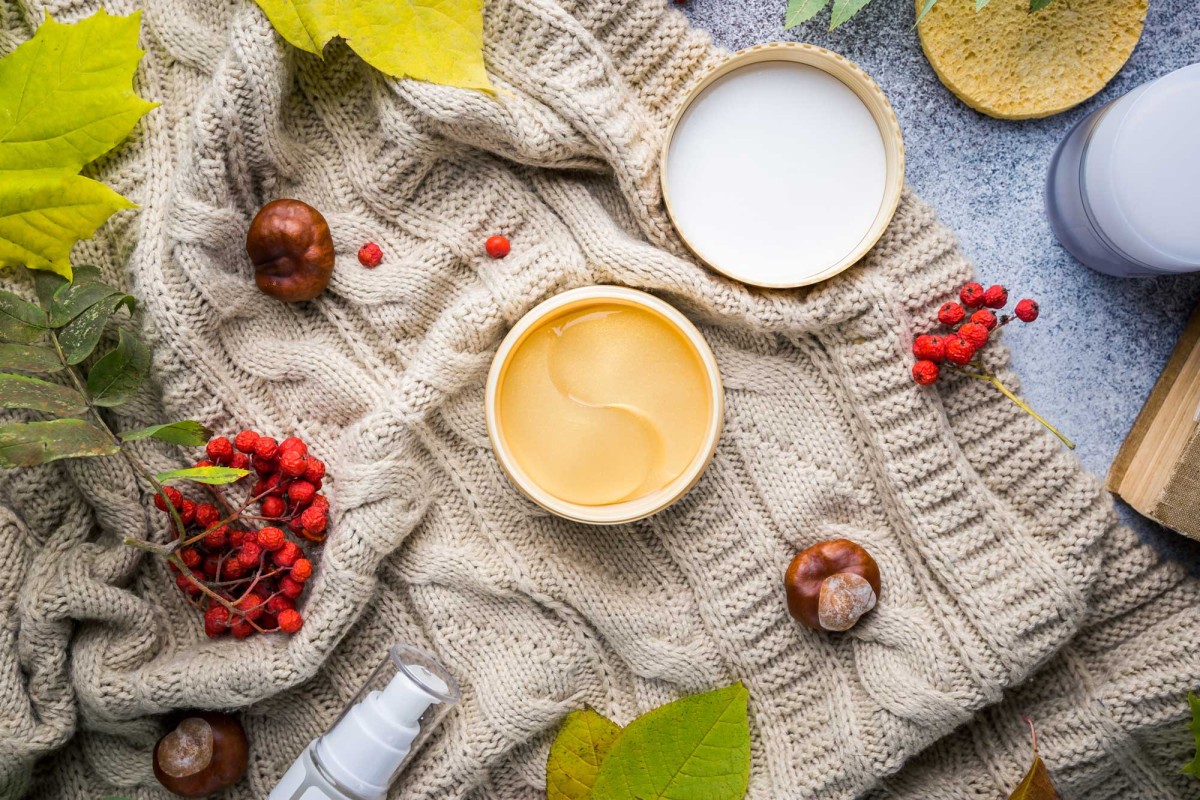 Autumn skincare products on cozy knitted sweater