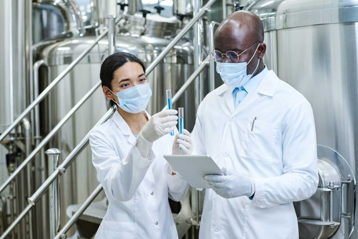 Scientists in lab coats analyzing test tube samples