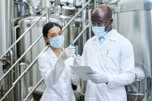 Scientists in lab coats analyzing test tube samples