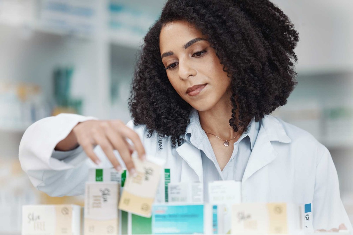 Pharmacist organizing skincare products on shelf