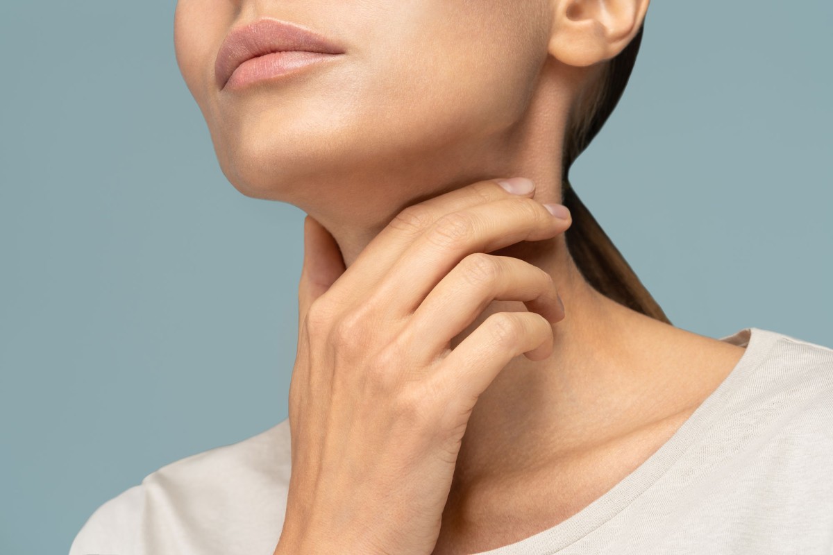 Close-up of woman touching her neck gently