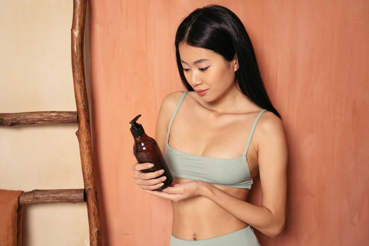 Woman examining hair product in amber bottle